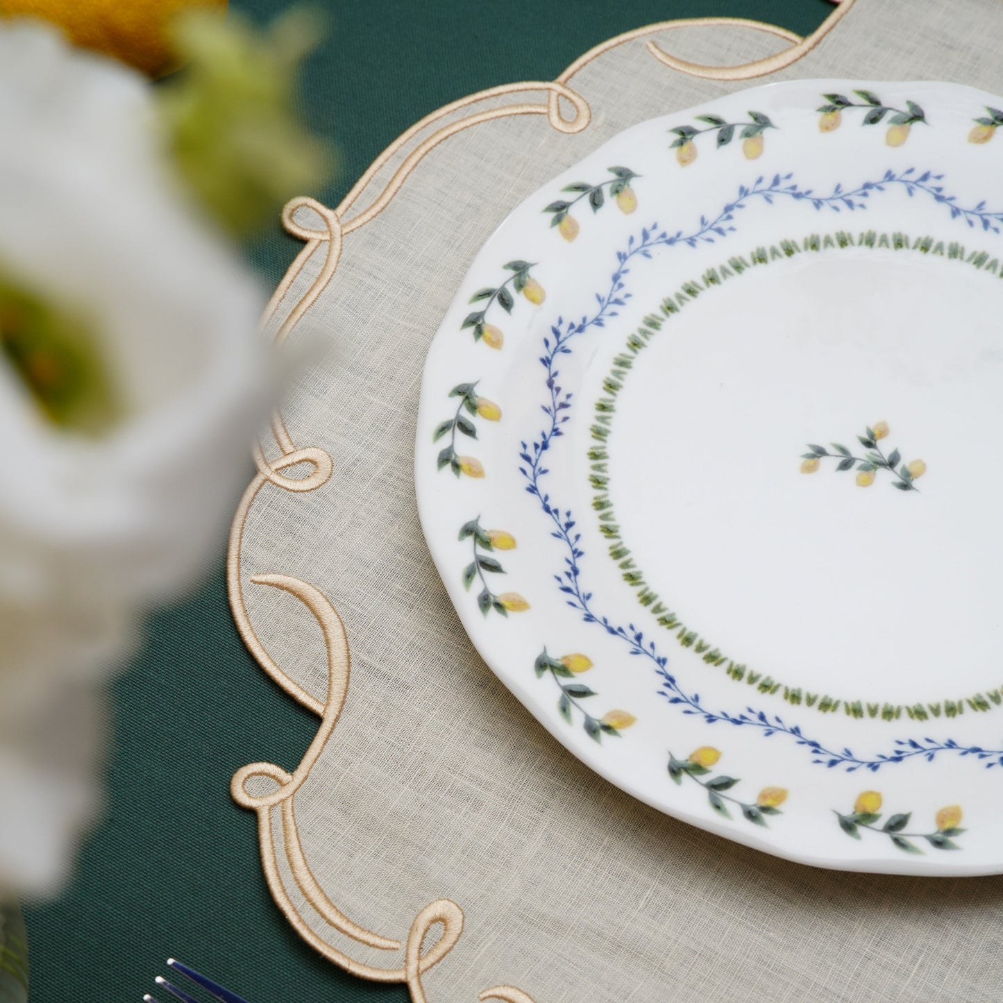 Sophisticated table setting featuring ivory and gold square placemat