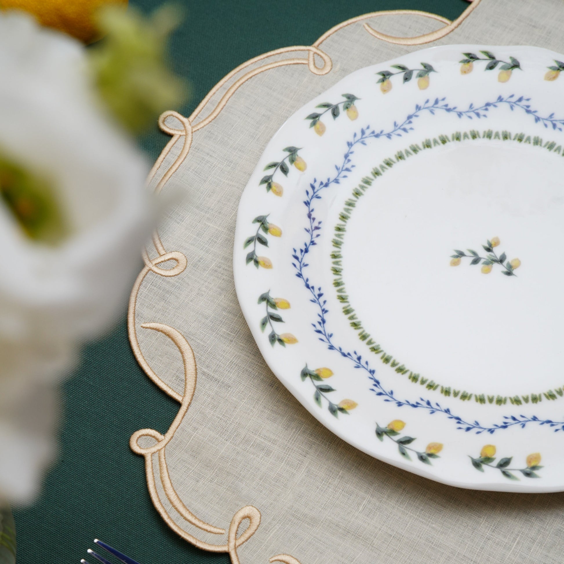 Sophisticated table setting featuring ivory and gold square placemat