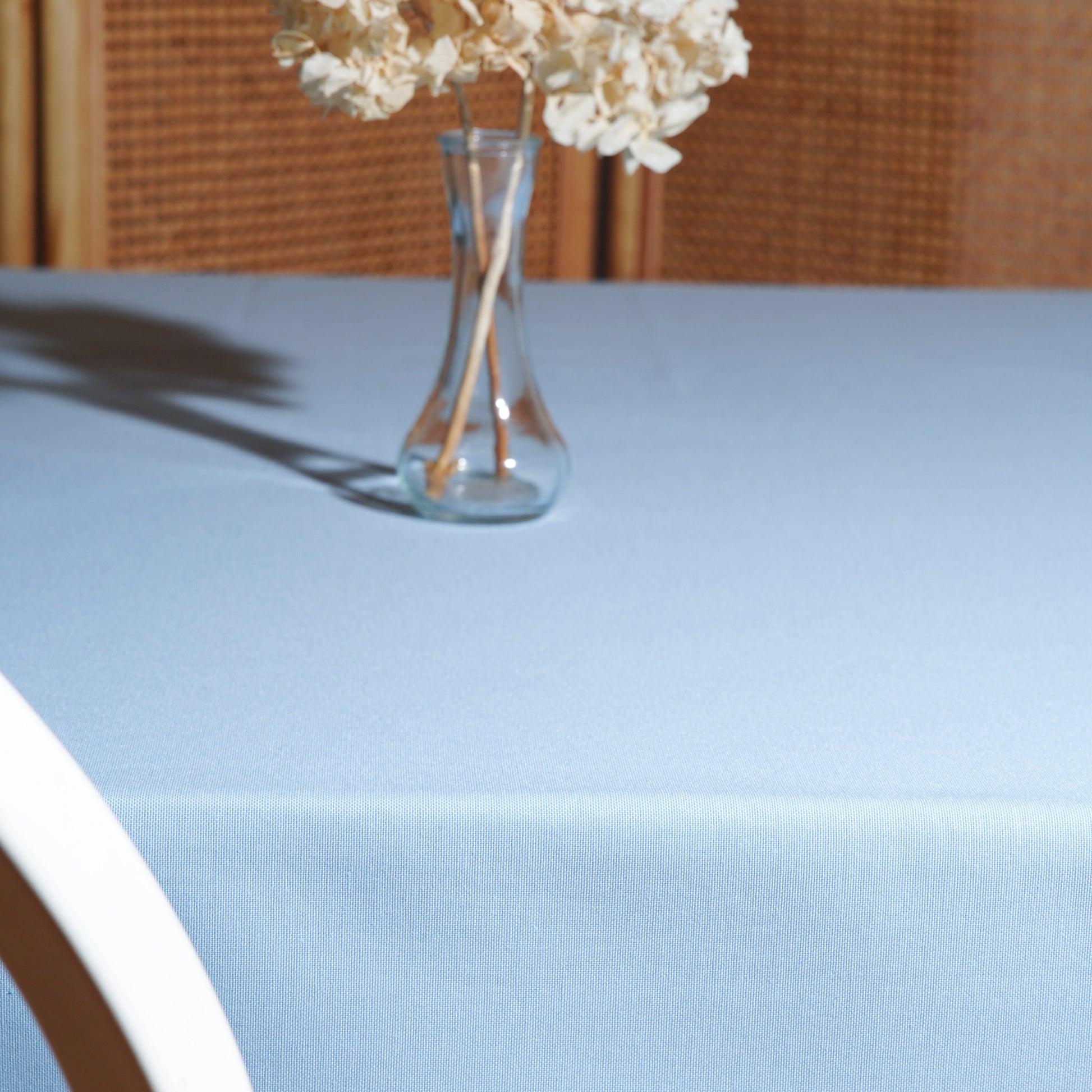 Close-up of the light blue tablecloth fabric texture showing a subtle woven pattern