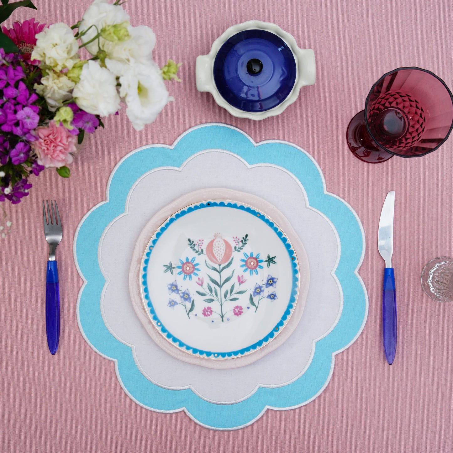 Soft-edged fabric placemat arranged with polished dinnerware