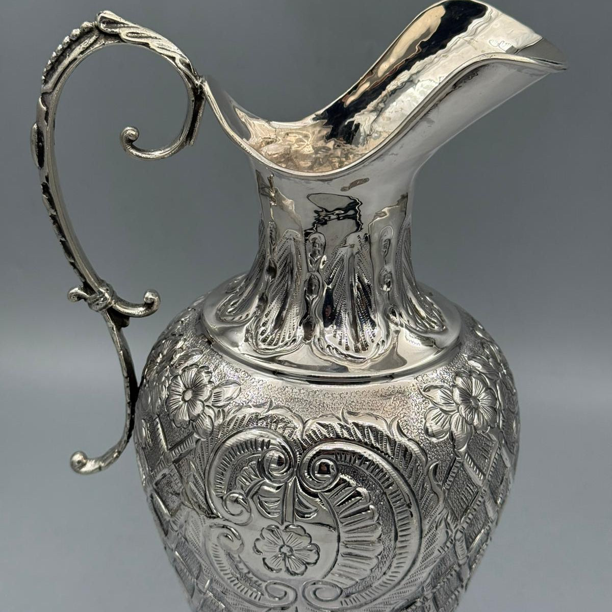 Detail of heavy floral engraving and medallion motif on silver pitcher by PNR Decor ship from USA