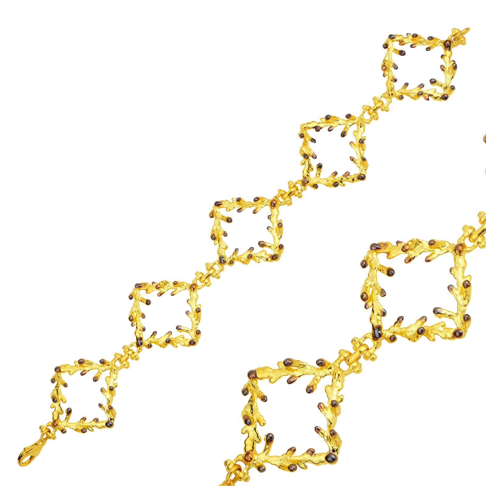 Close-up detail of the heavy two-tone pine branch bracelet. The intricate wood texture of the gold-plated square links is highlighted by striking darkened silver accents on the leaf nodes.
