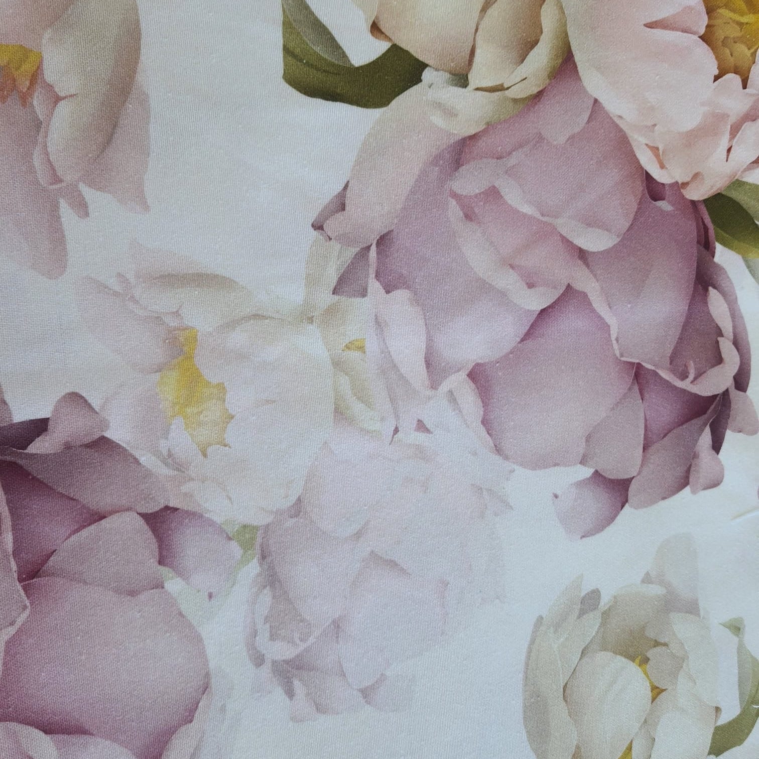 Close-up of a pastel peony floral tablecloth showing soft pink and ivory blooms with a watercolor-style look