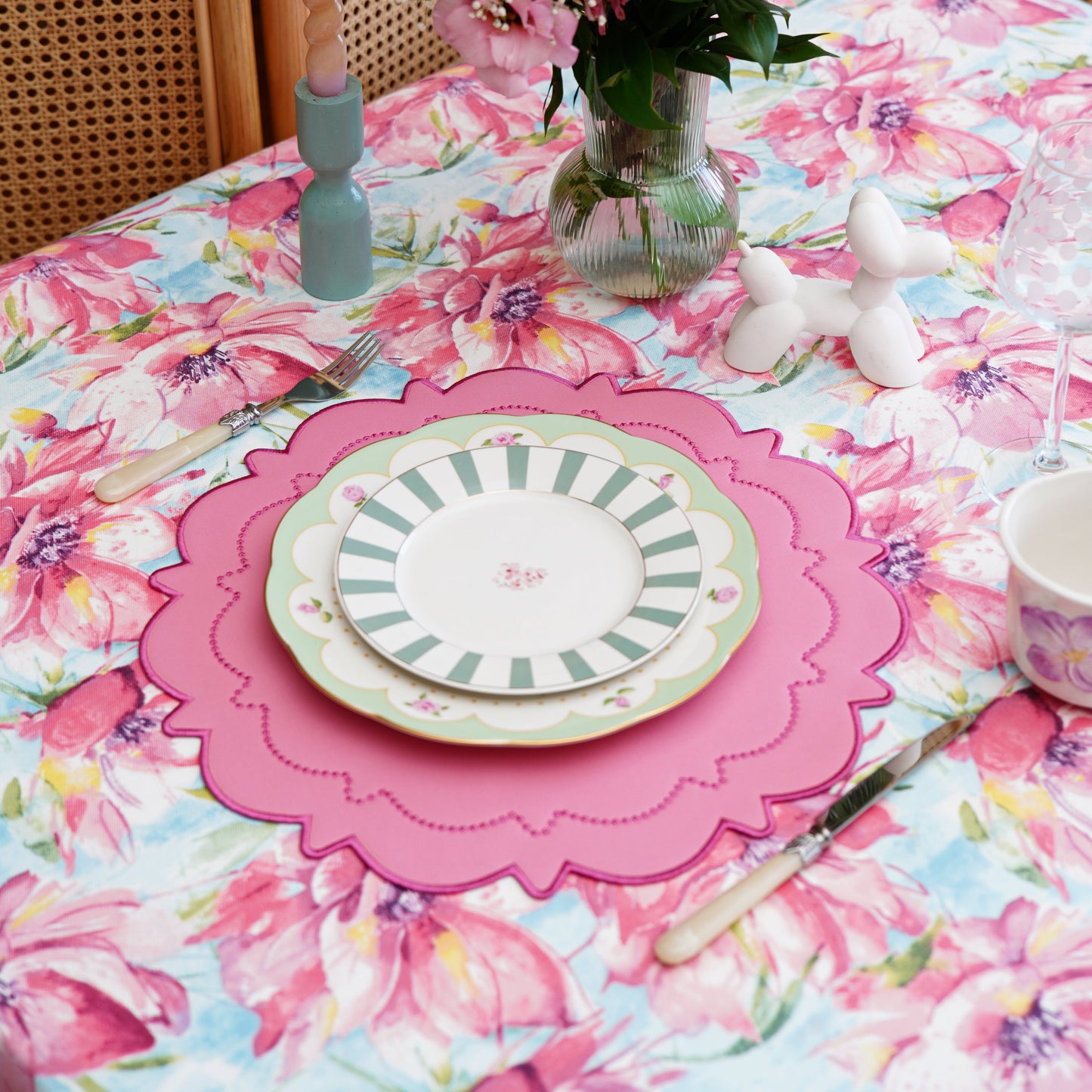 Close-up of the pink floral pattern on the tablecloth, showing soft watercolor petals and fine fabric texture