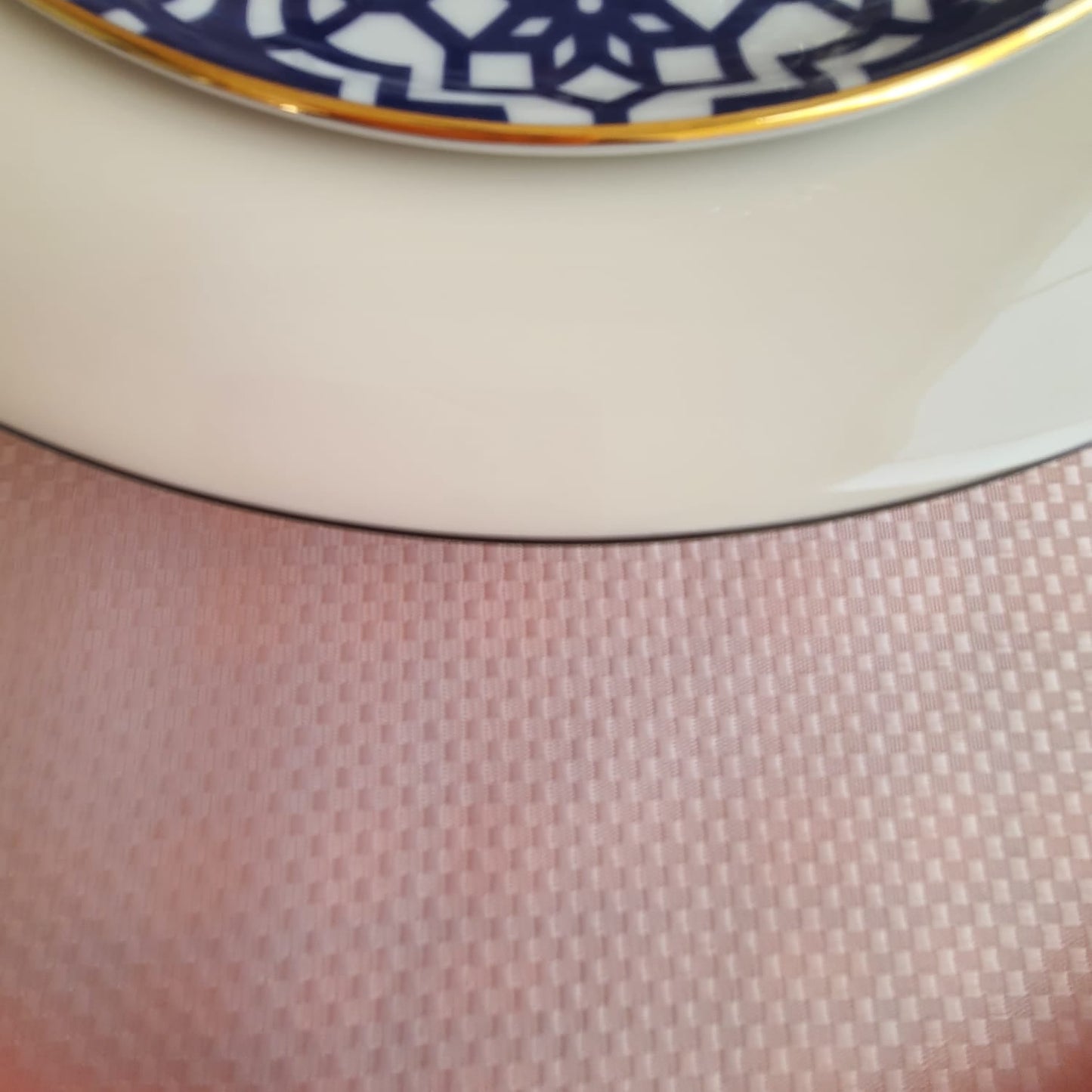 Solid pink tablecloth draped over the table edge, showing the neat hem and elegant fall