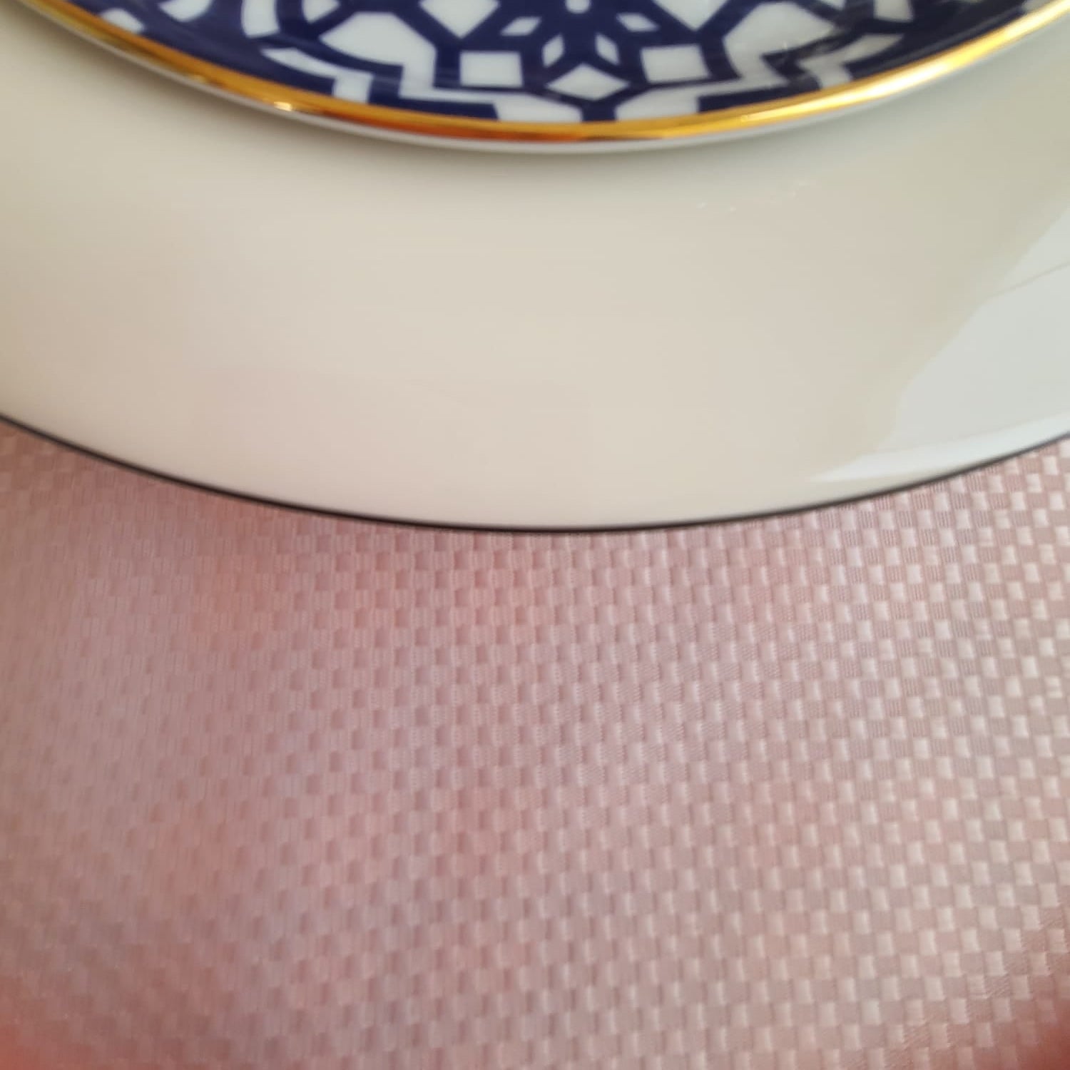 Solid pink tablecloth draped over the table edge, showing the neat hem and elegant fall