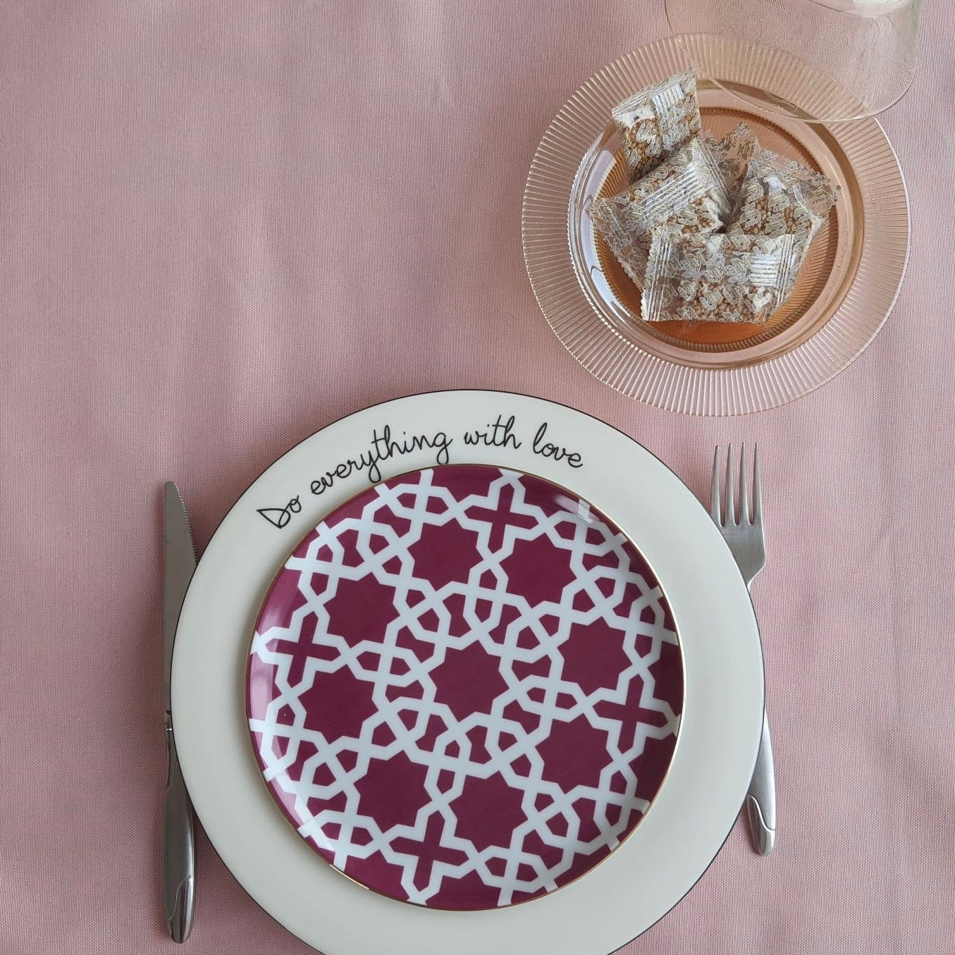 Top view of a pink tablecloth with a complete place setting, highlighting the soft solid color and clean look
