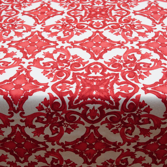 Close-up of a red and white damask tablecloth featuring an ornate ornamental pattern and woven texture