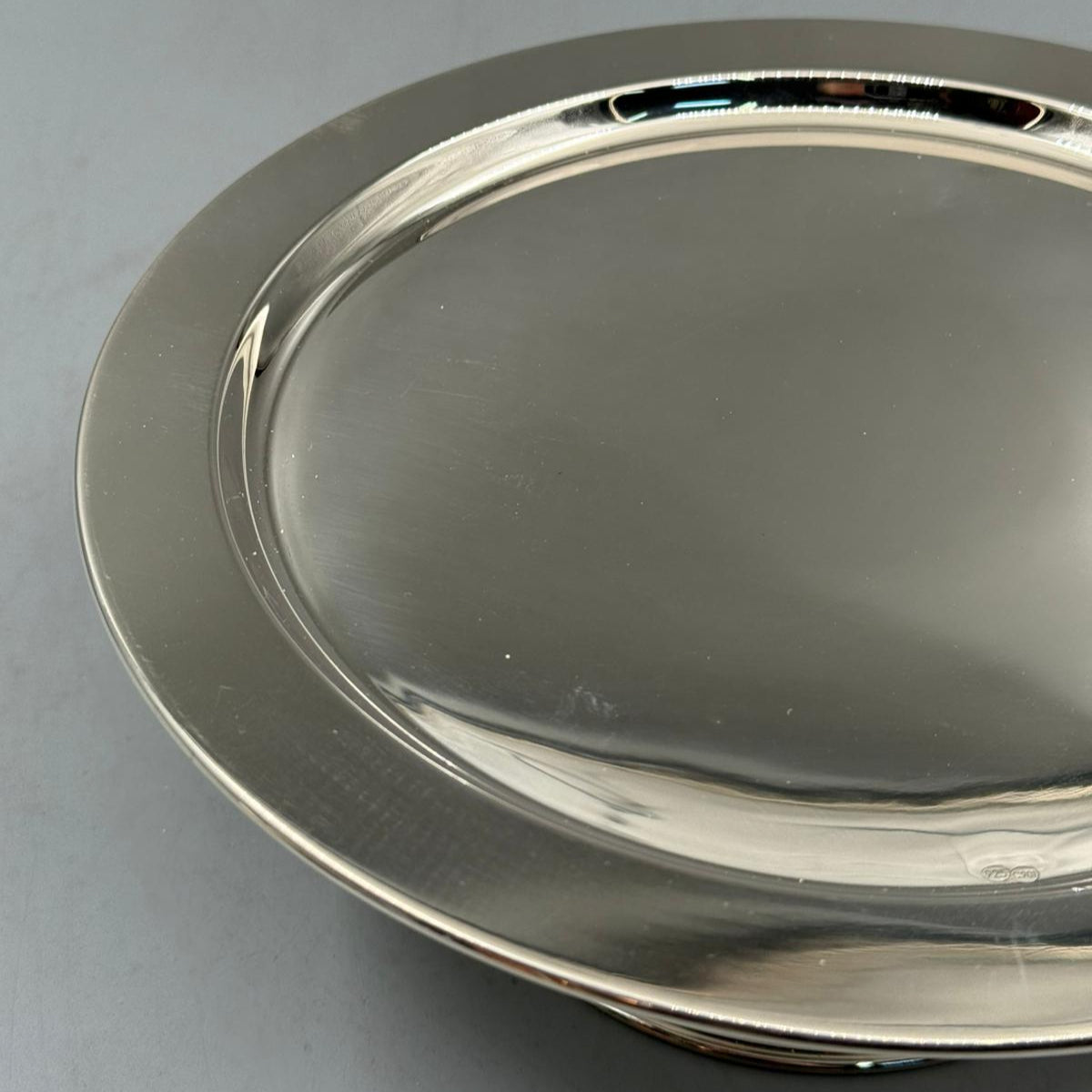 Round silver dish plate with polished surface, ideal for serving or decorative use