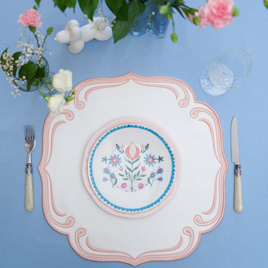 Elegant square placemat styled on a formal dining table with detailed trim