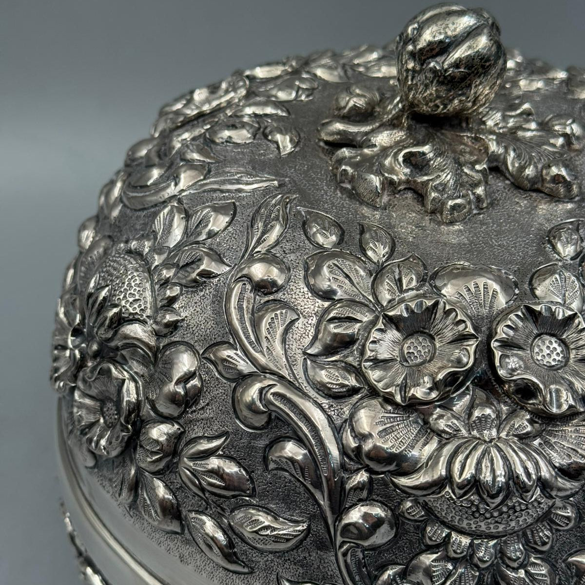 Extreme close-up of the sand-cast (kum kakma) texture and deep-relief floral engravings on the 900 sterling silver body.