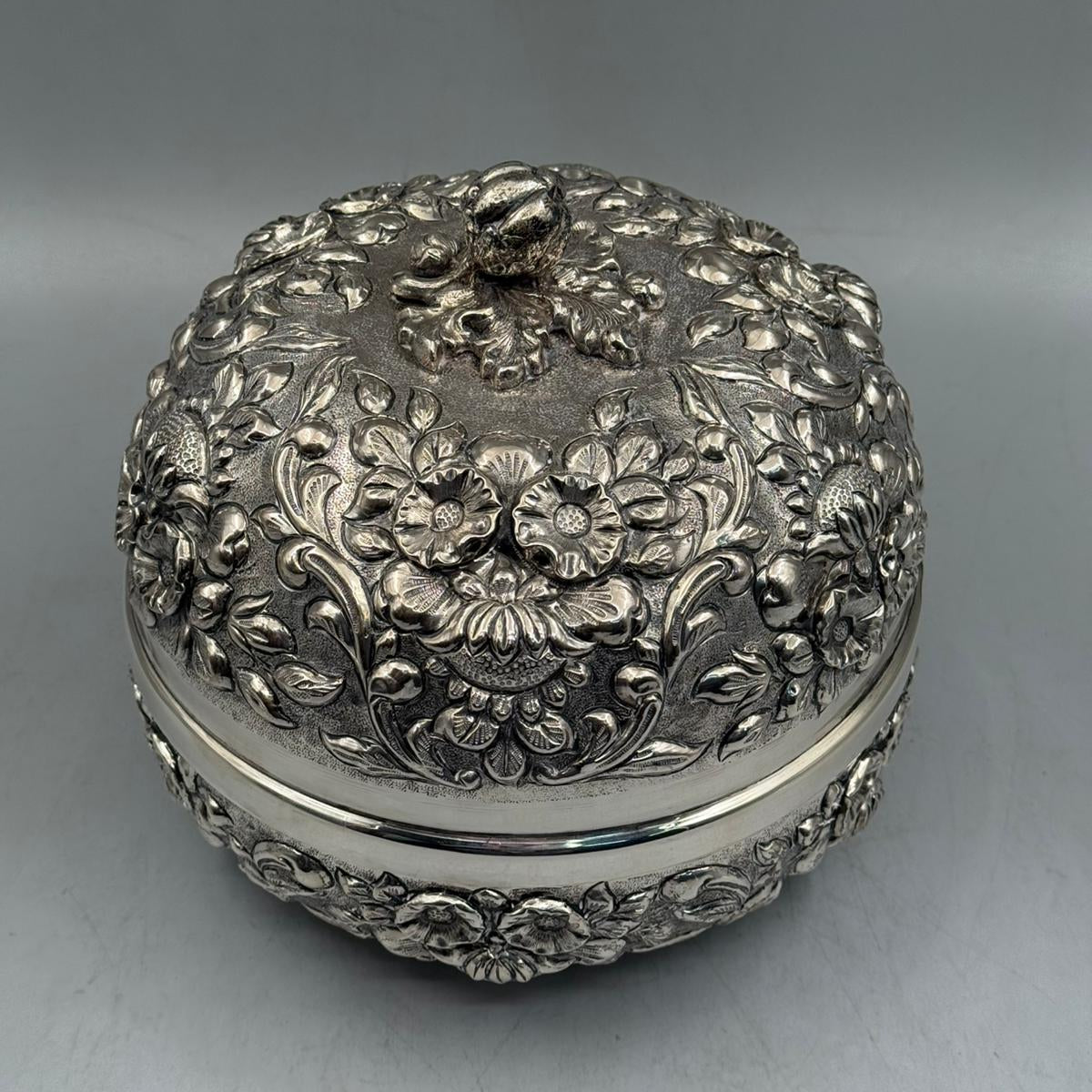 Top-down view showcasing the meticulous hand-engraved floral patterns and the sculpted silver rose handle on the dome-shaped lid.
