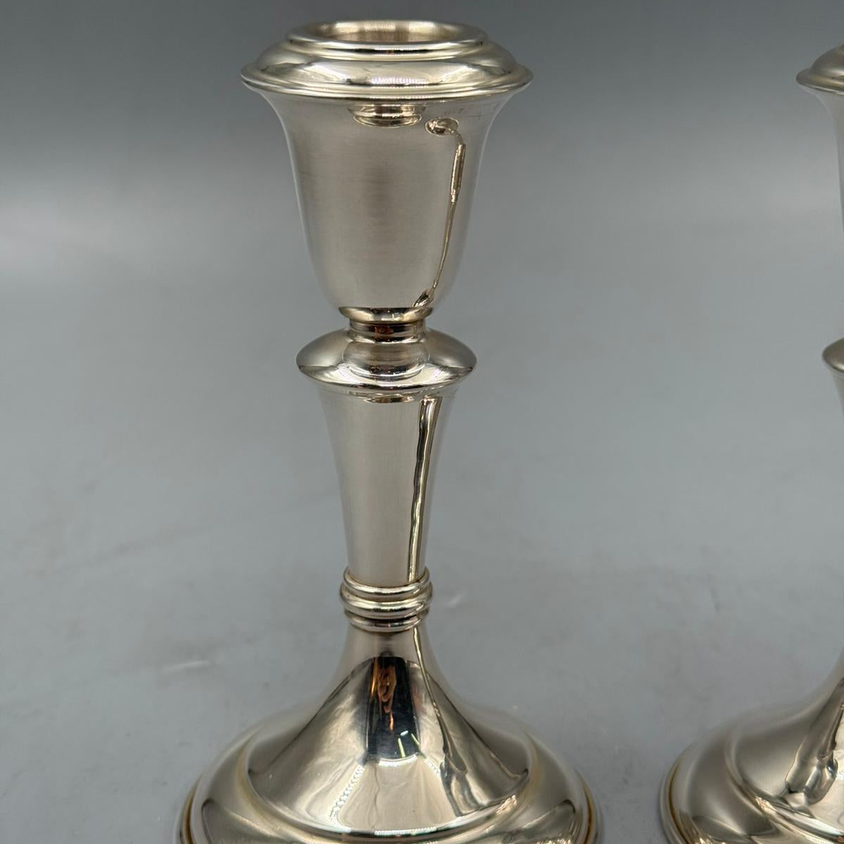 Top view of polished silver candle holders with wide bases and simple classic design.