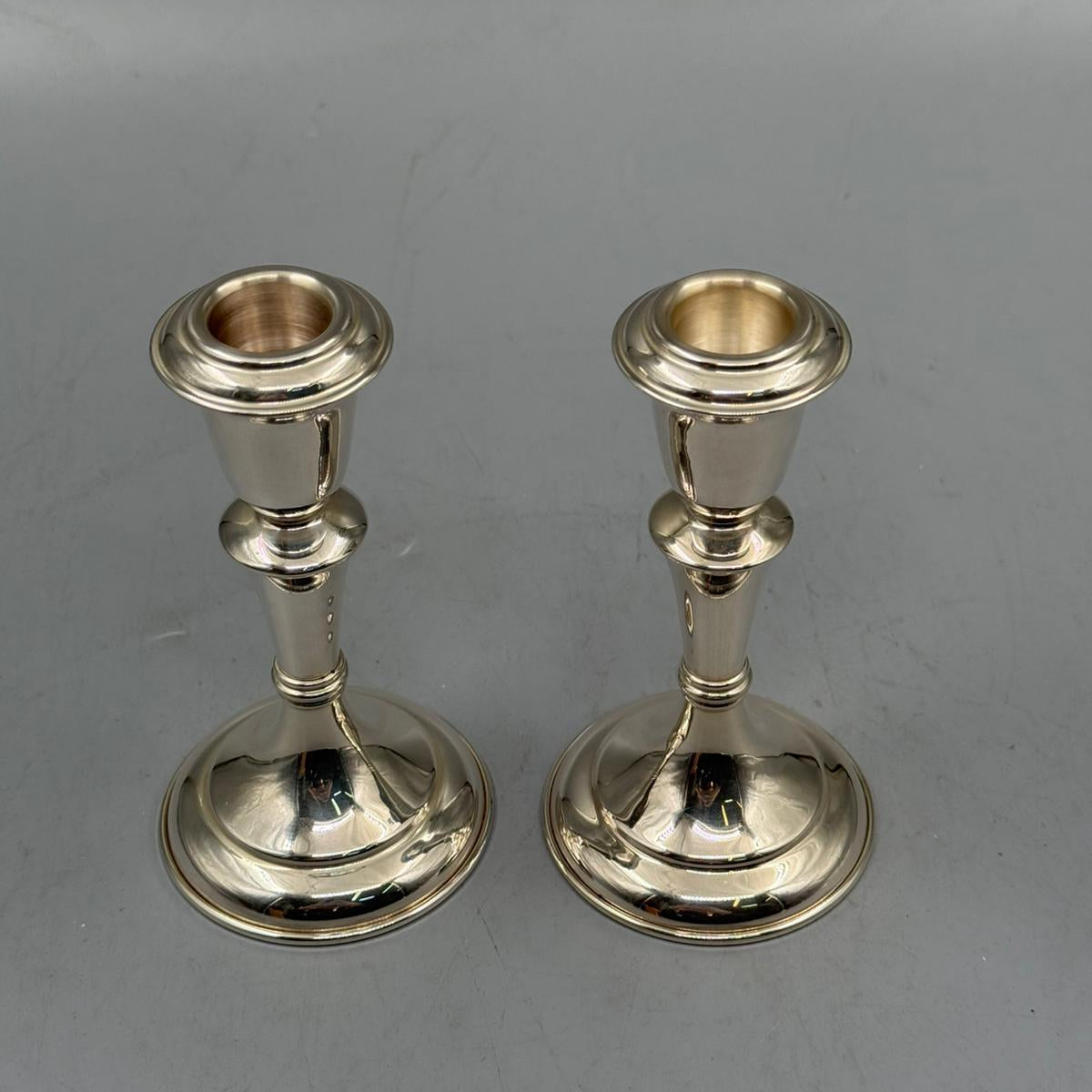 Close-up of a classic silver candle holder with smooth polished finish and elegant curves.