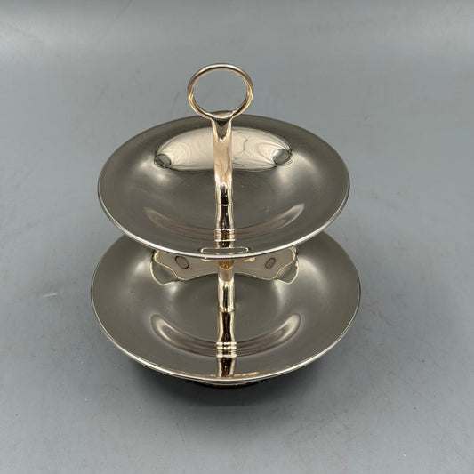 Polished silver two tier fruit stand with handle, ideal for serving apples, grapes, and desserts