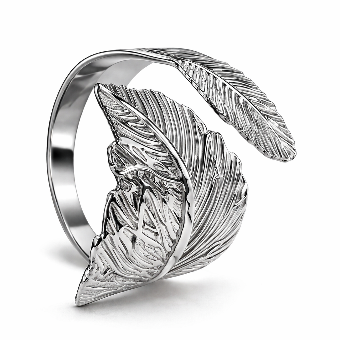 A close-up studio shot of an elegant silver metal napkin ring featuring a detailed wrap-around leaf design, set against a pristine white background.