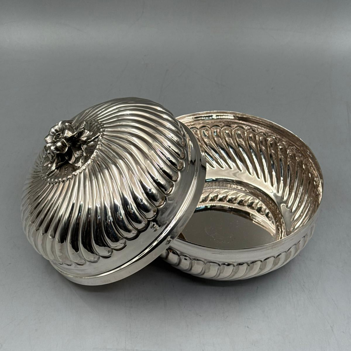 Detailed view of the radial swirled ribbing and craftsmanship on the handcrafted 900 sterling silver statement piece.