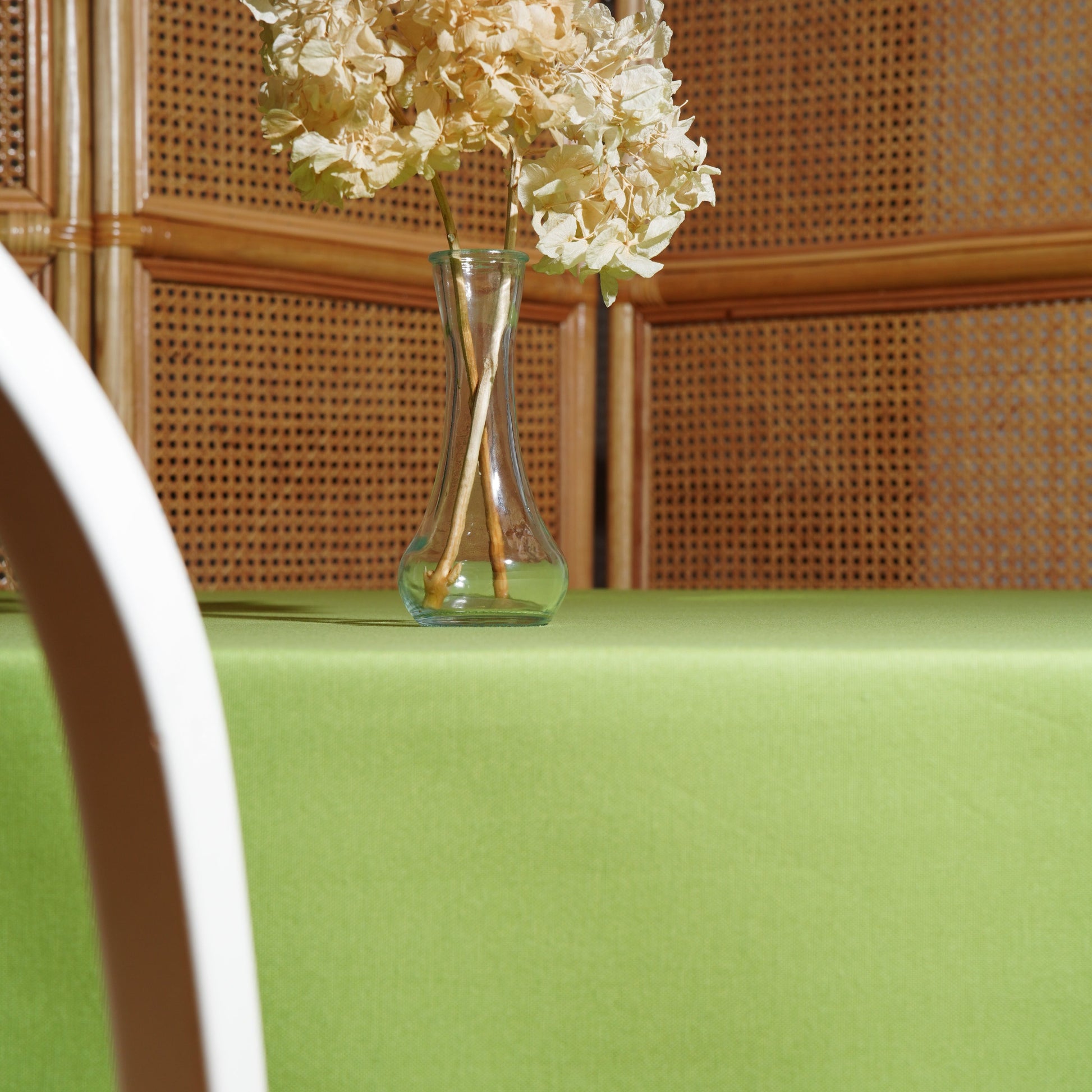 Spring green table linen draped over the table edge, highlighting the neat hem and smooth fall