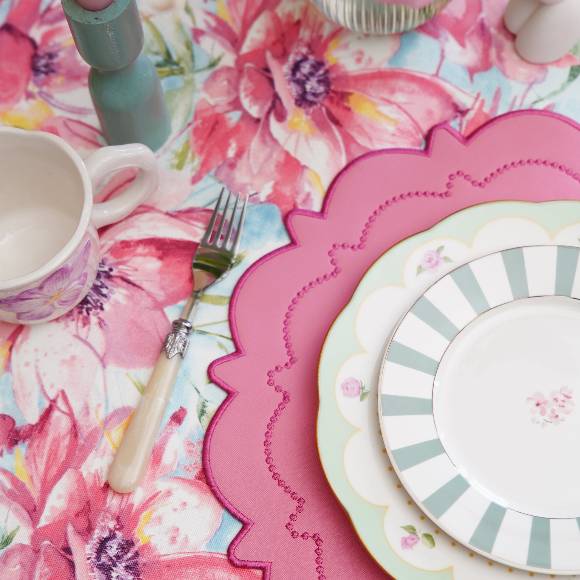 Top view of a spring-inspired pink flower tablecloth with large blooms and pastel tones.