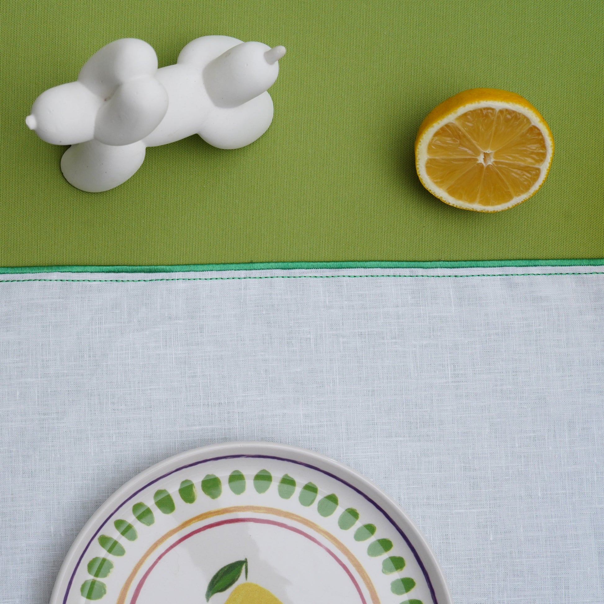Close-up of white placemat showcasing subtle leaf design stitching