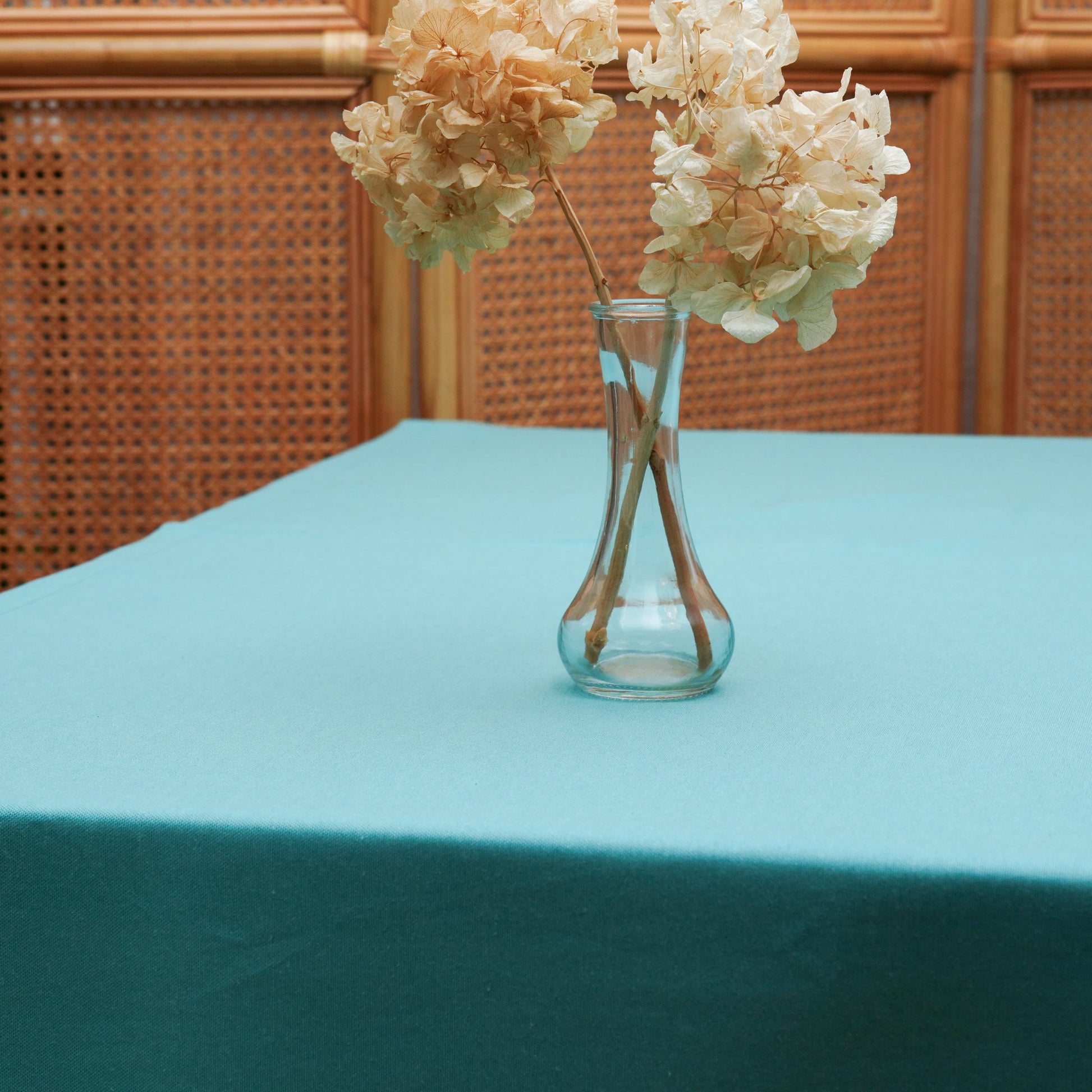 Close-up of the turquoise tablecloth showing a clean solid finish and subtle woven fabric texture