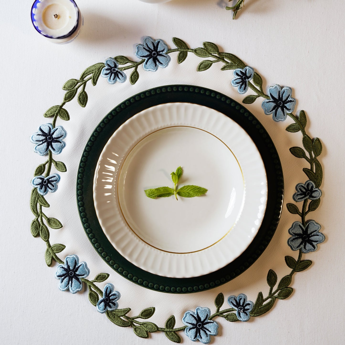 Elegant spring tablescape showing the premium white and blue vegan leather mat for sophisticated dining setups