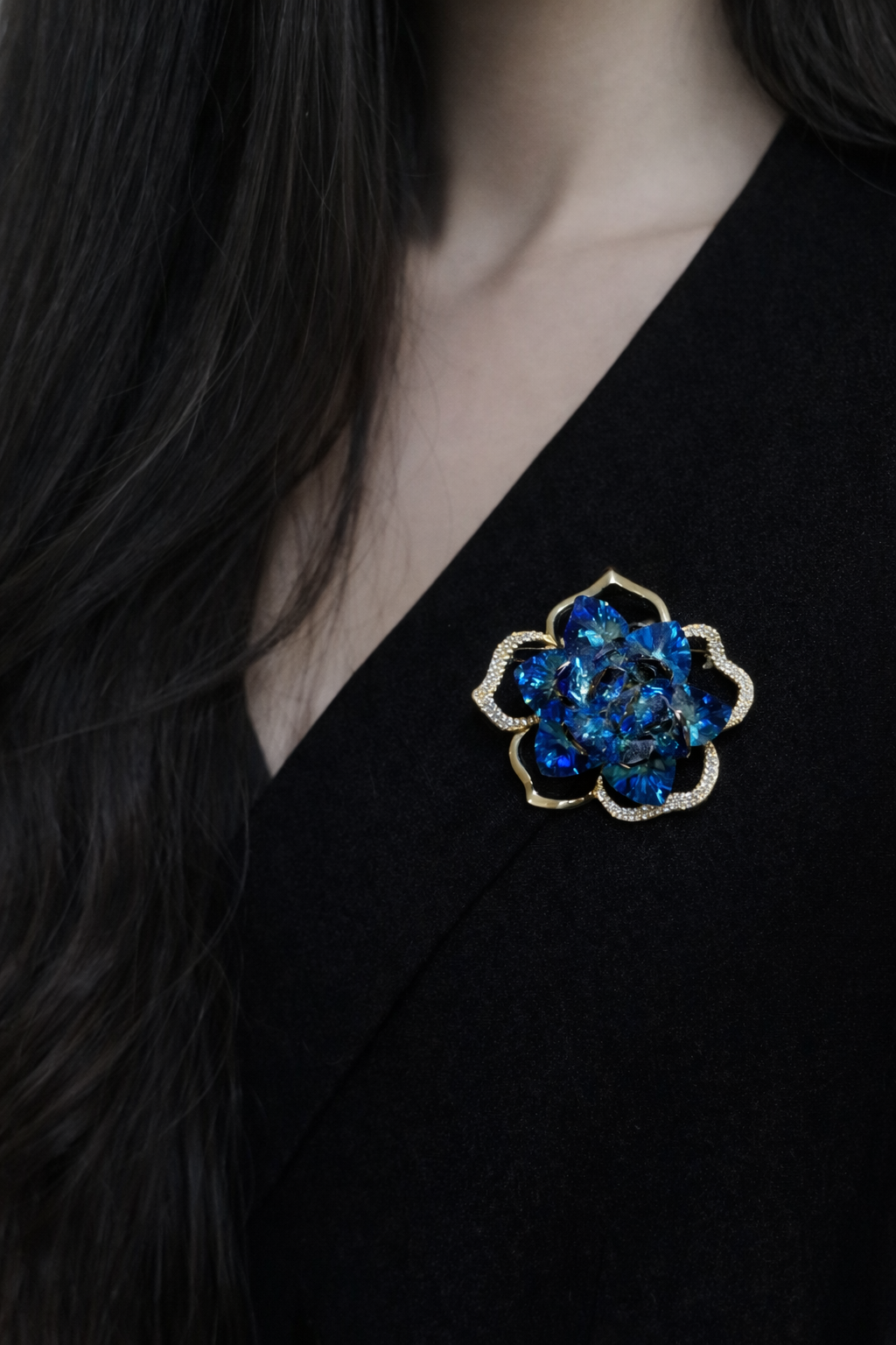 A sophisticated vintage-style gold-plated brooch featuring deep navy and vibrant red enamel accents, decorated with sparkling clear crystals in an elegant royal emblem design.
