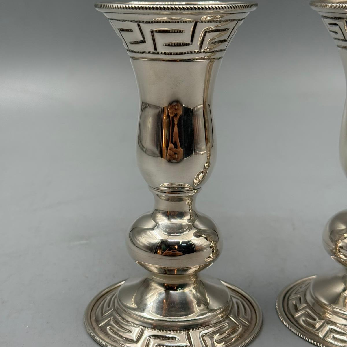 Set of two vintage silver candle holders with engraved Greek key pattern.