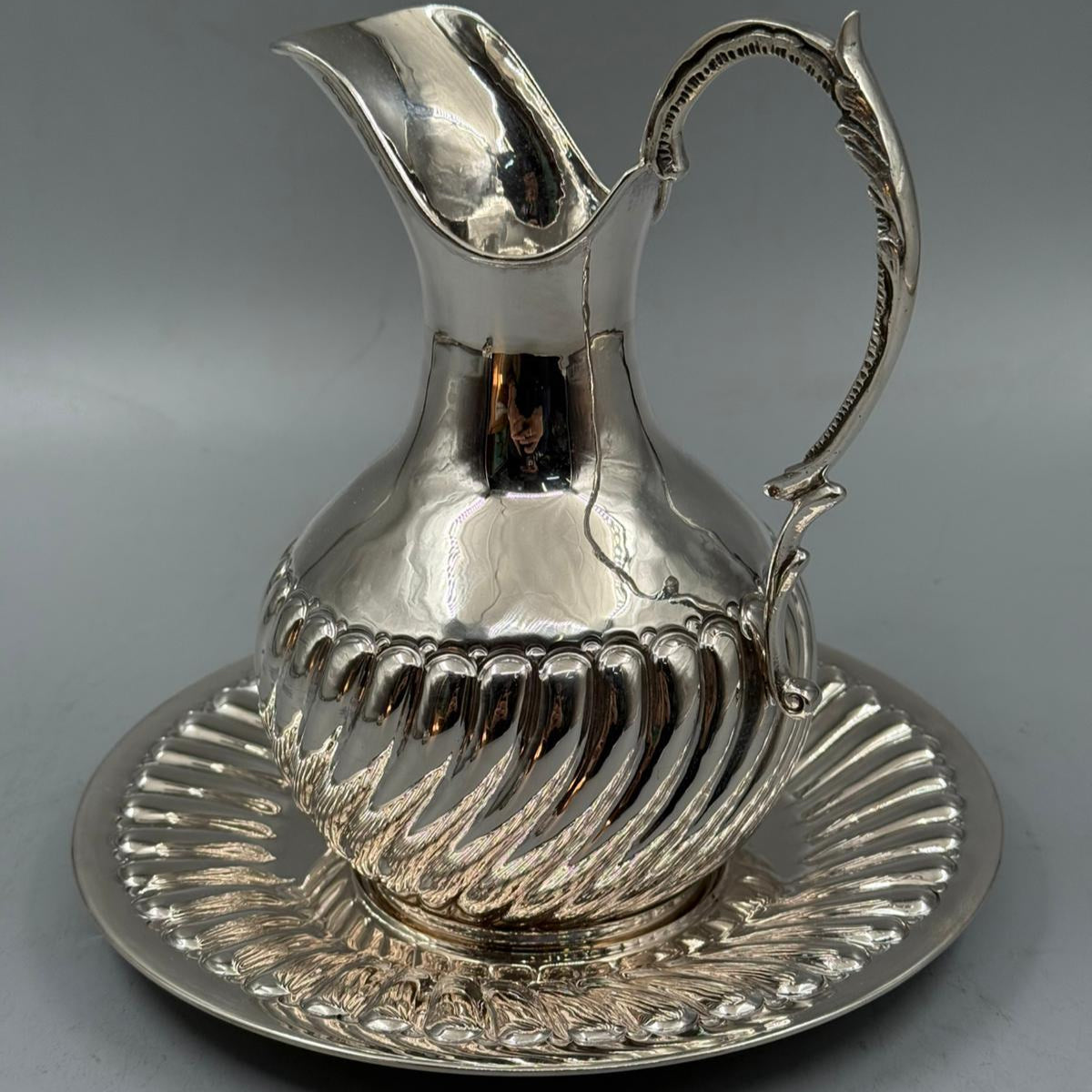 Vintage silver jug with artistic handle and matching tray for serving or display
